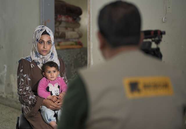 A woman holding her daughter on her lap
