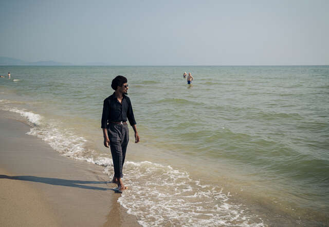 En man som flytt över Medelhavet från Nordafrika går längs stranden i Italien, dit han kom för drygt tio år sedan.