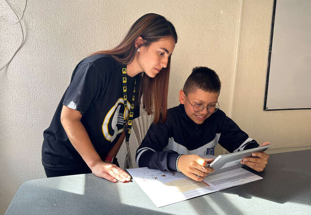 Juanita, IRC Education Senior Officer and Daniel navigate a lesson using AudioClass system.