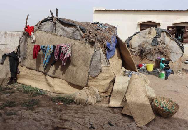 View of an informal displacement site in Ténenkou, Mali. These makeshift shelters, built from salvaged materials, are typical of those found in camps for internally displaced people (IDPs) in the area. They offer only minimal protection to families who have been forced to flee their homes due to violence and insecurity.