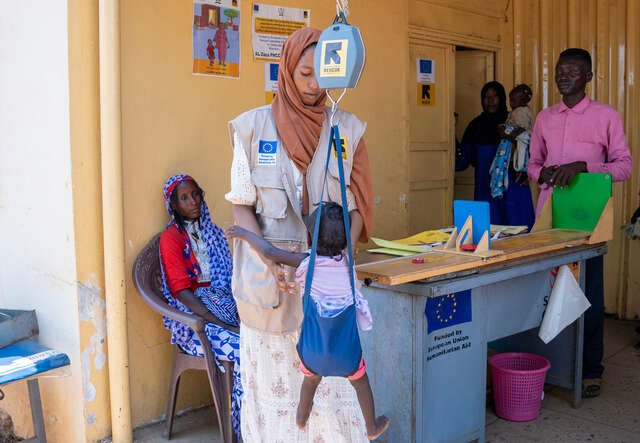Zainab is weighed at the clinic to assess her malnutrition status as part of her routine screening check up.