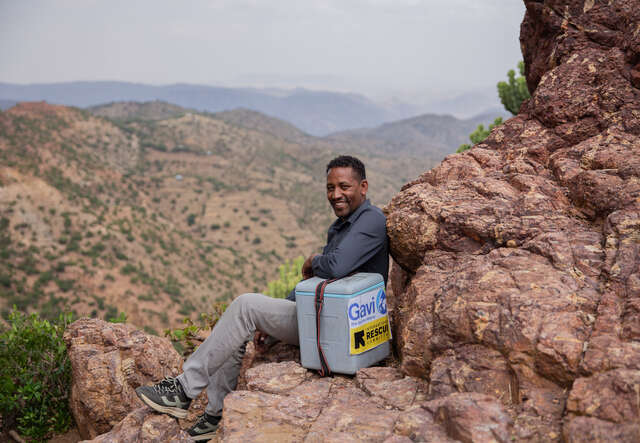 Vid en bergssluttning i Etiopien sitter en av RESCUE:s hälsoarbete och tar en paus under sin vandring för att nå fram med vaccin till avlägsna platser.