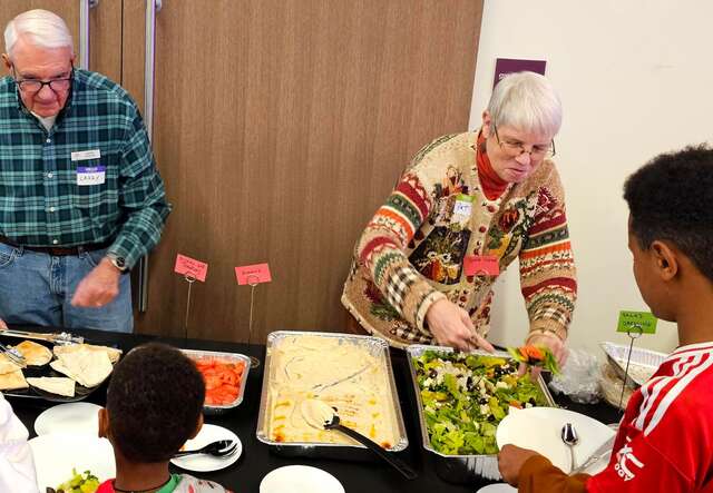 Volunteers serve food.