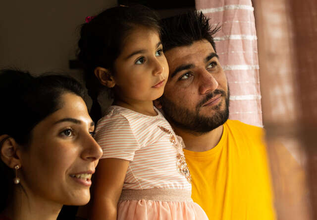 Maasom, Hiba and Nasrin look out the window together of their home in Hampshire.