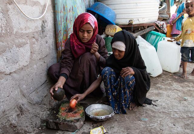 Aisha, 10, and Na'aem, 11, cook in a camp for internally displaced people (IDP) in Yemen.
