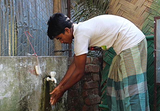 A young refugee washes his hands at a crowded refugee camp in Cox's Bazar, Bangladesh, where the IRC is providing support to Rohingya refugees from Myanmar.