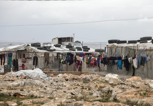 Clothes hang in settlement for displaced Syrians on outskirts of Deir Hassan in Idlib