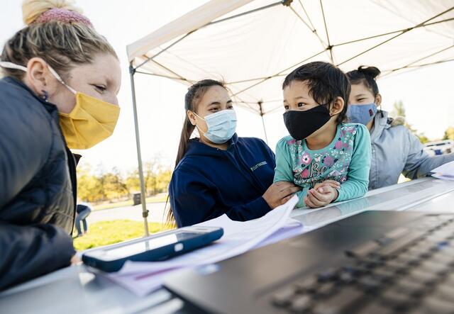 Young Family sitting at a table with an International Rescue Committee employee