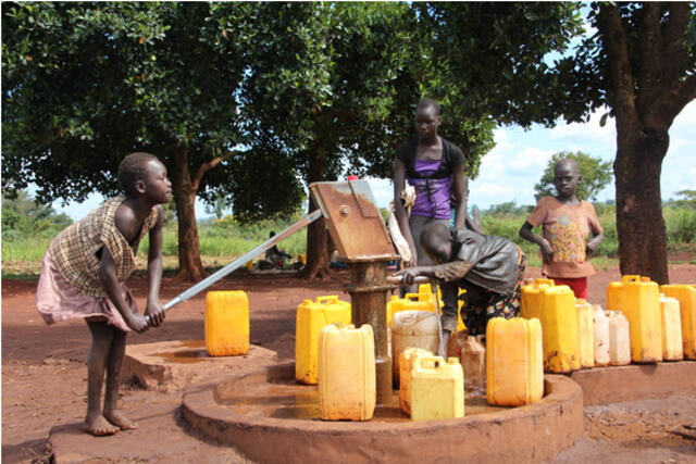 Children collect water from an IRC-installed water point in the Kiryandongo refugee camp