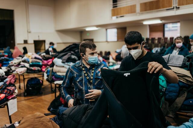 IRC staff member provides interpretation for a young man at the IRC in Salt Lake City's Warm Welcome Winter Clothing Drive