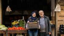 A daughter and father poses for a photo outside of their shop in Lebanon.