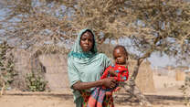 A Sudanese refugee and her one-year-old child in the dry landscape in Kafia, Chad, where IRC medical staff tested her daughter for malnutrition.