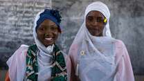 Two students stand at the front of a school in Chad and pose for a photo.
