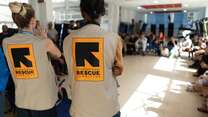 Two IRC staff members address a group of asylum seekers in Italy.
