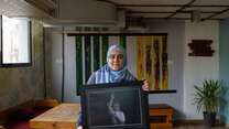 A Syrian refugee and photographer shows off her artwork at a studio in Amman, Jordan.