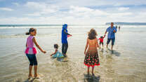 The Tlas family from Syria play in the surf at a California beach 