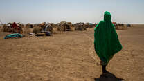 A woman walks to her temporary shelter in a remote village in the drought-affected Somali region of Ethiopia. 