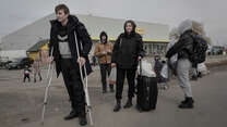 A family flee Ukraine with a young man using crutches 