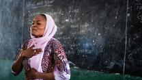 A teacher in Nigeria demonstrates mindfulness breathing techniques to students