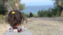 A refugee child on the island of Lebos, in Greece, looks out toward the sea