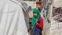 Syrian girl stands in front of her uncle’s tent in Idlib countryside
