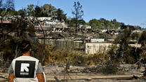 An IRC staff member views the burnt-out Moria refrugee camp in Lesbos, Greece