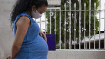 A pregnant Venezuelan woman rests her hand on her stomach in Colombia