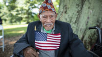 A seated refugee man holds a flag at a citizenship ceremony in Virginia