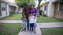 Robert, Edith and their young daughter and son stand for a photo on the sidewalk outside their home in Arizona