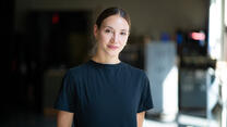 With her hair pulled back and wearing a black t-shirt, Christine Shevchenko looks at the camera for a World Refugee Day 2021 photo shoot,