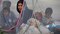 An Afghan mother sits in a tent with her young boys at a makeshift IDP camp.