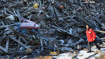 A Japanese aid worker walks through the debris of ruined buildings near the city of Kamaishi.