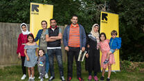 Two families pose together at the first IRC RISE graduation in Horsham, UK.