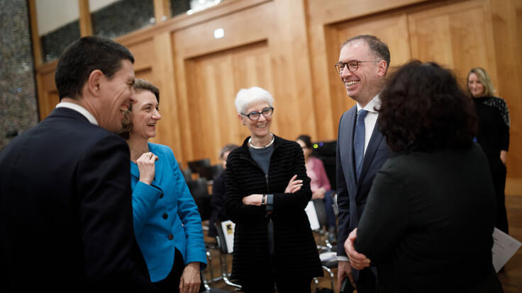 Eine Gruppe von Menschen steht in einem Kreis und alle lachen sich an