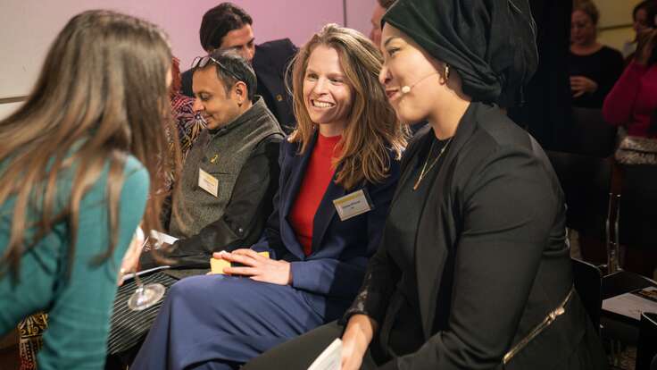 Vier Personen sitzen im Publikum