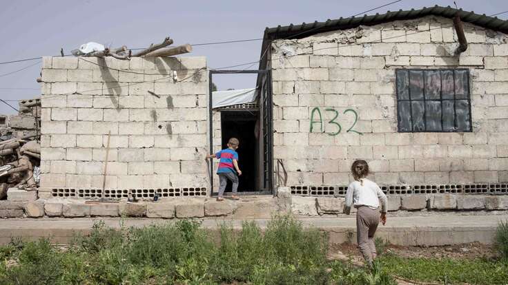 Zwei Kinder rennen in ein Gebäude