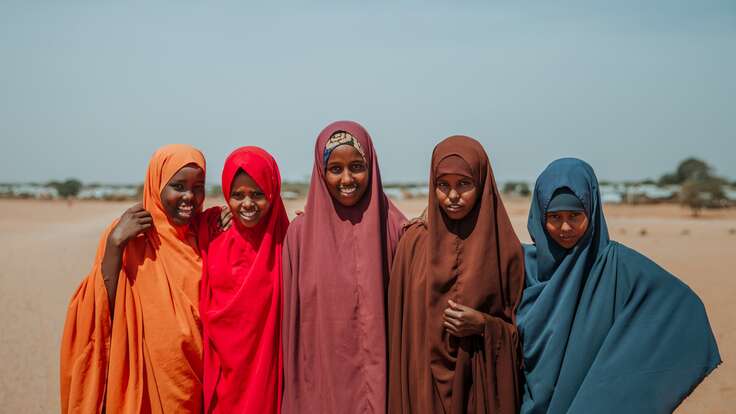 Fünf Mädchen, die am IRC-Programm Girl Shine teilnehmen - Ampia, Asha, Hibo, Shamsa und Nurta - stehen zusammen für ein Foto in einer trockenen Landschaft in Äthiopien.