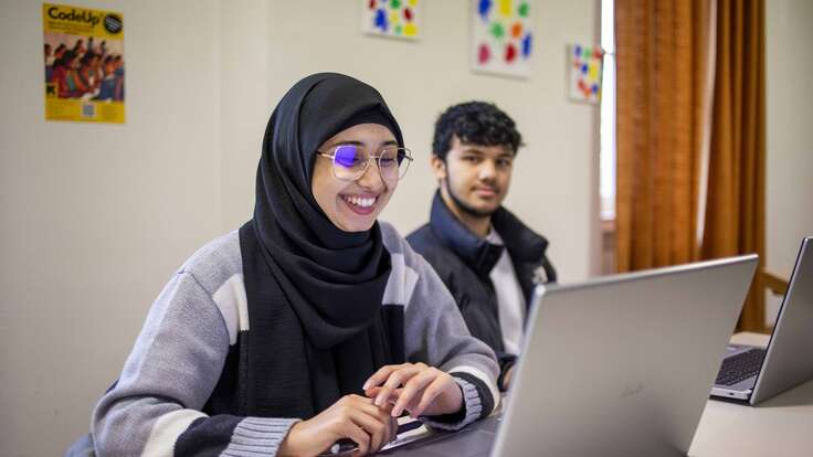 Afghanische Frau und Mann in Deutschland beim gemeinsamen Arbeiten am Laptop.