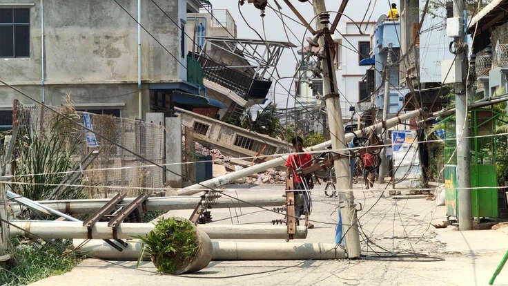 A man examines a downed power line caused by the earthquake in Myanmar.