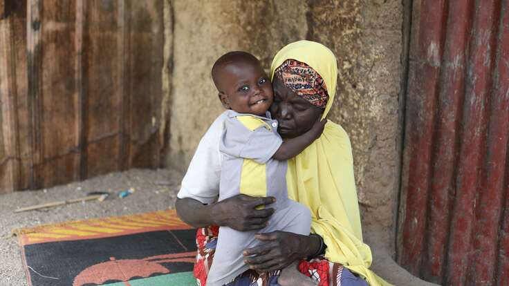 할머니 아미나가 활짝 웃는 손자 압둘라히를 품에 안고 있습니다.