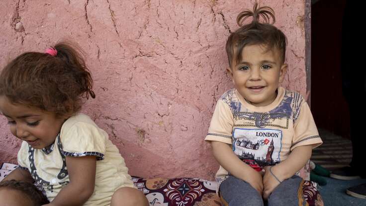 포니테일 머리를 한 어린이가 카메라를 바라보고 웃고 있습니다.