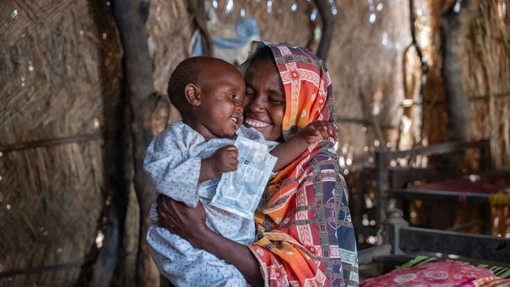 Anwar’s mother, Shama, plays with him inside their home in Al-Azaza.