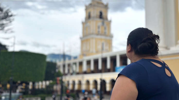 Woman looking at a building, we see her from the back.
