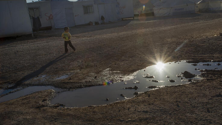 A boy plays near a puddle of waste water at the Zaatari refugee camp in northern Jordan.