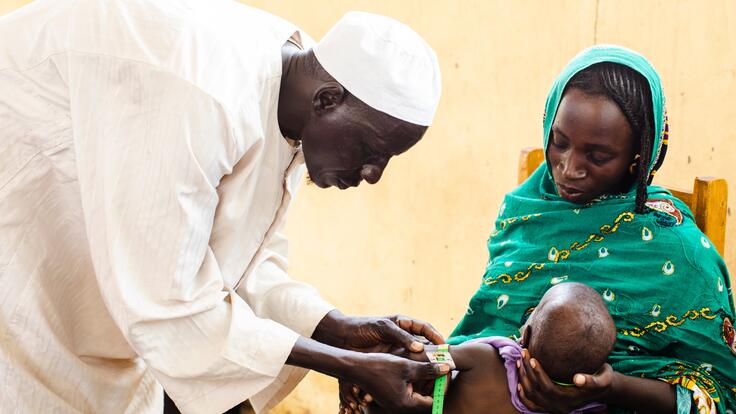 A mother holds her baby during an exam for acute malnutrition at an International Rescue Committee supported health center in Chad.
