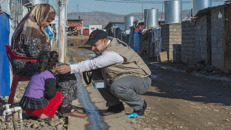A man speaking to two women.