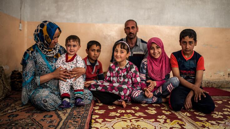 A family sitting on a wall together.